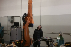 mike slaco looking at a kuka arm raised in the air lol